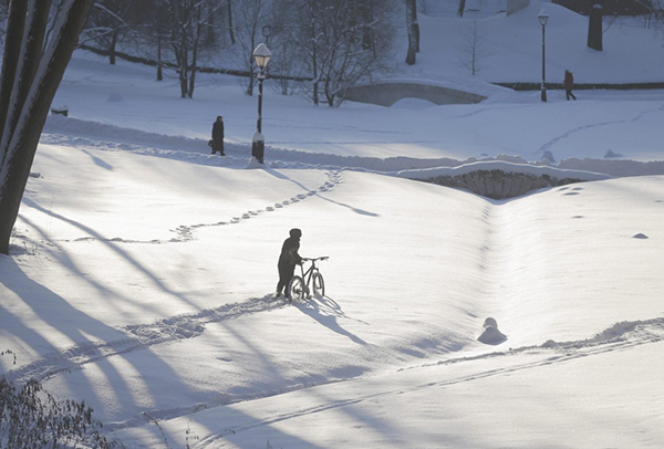 Un ciclista in un parco coperto di neve