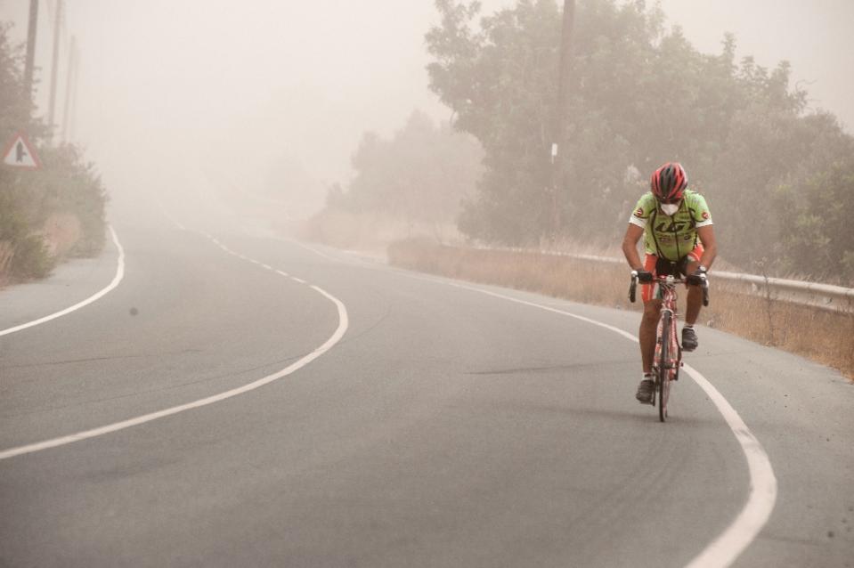 Ciclista a Cipro durante una tempesta di sabbia