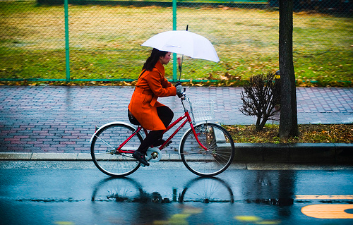 Donna in bici com ombrello